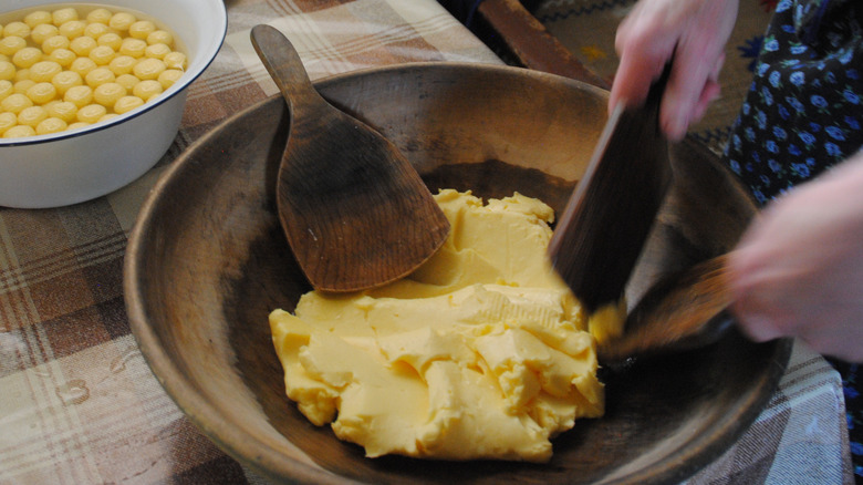 Pressing buttermilk out of raw butter to ensure a longer shelf life.