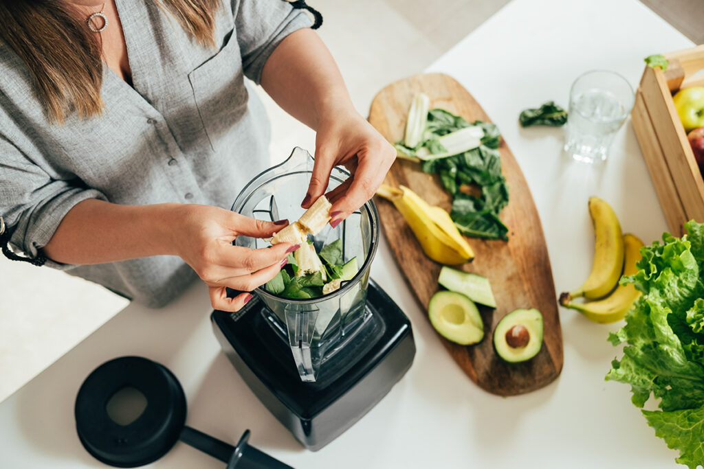 Young woman making a plant based smoothie.