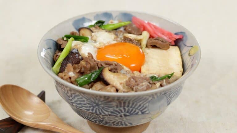 Bowl of Sukiyaki with raw egg.
