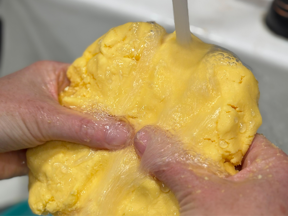 Rinsing raw butter in cold water to remove buttermilk.