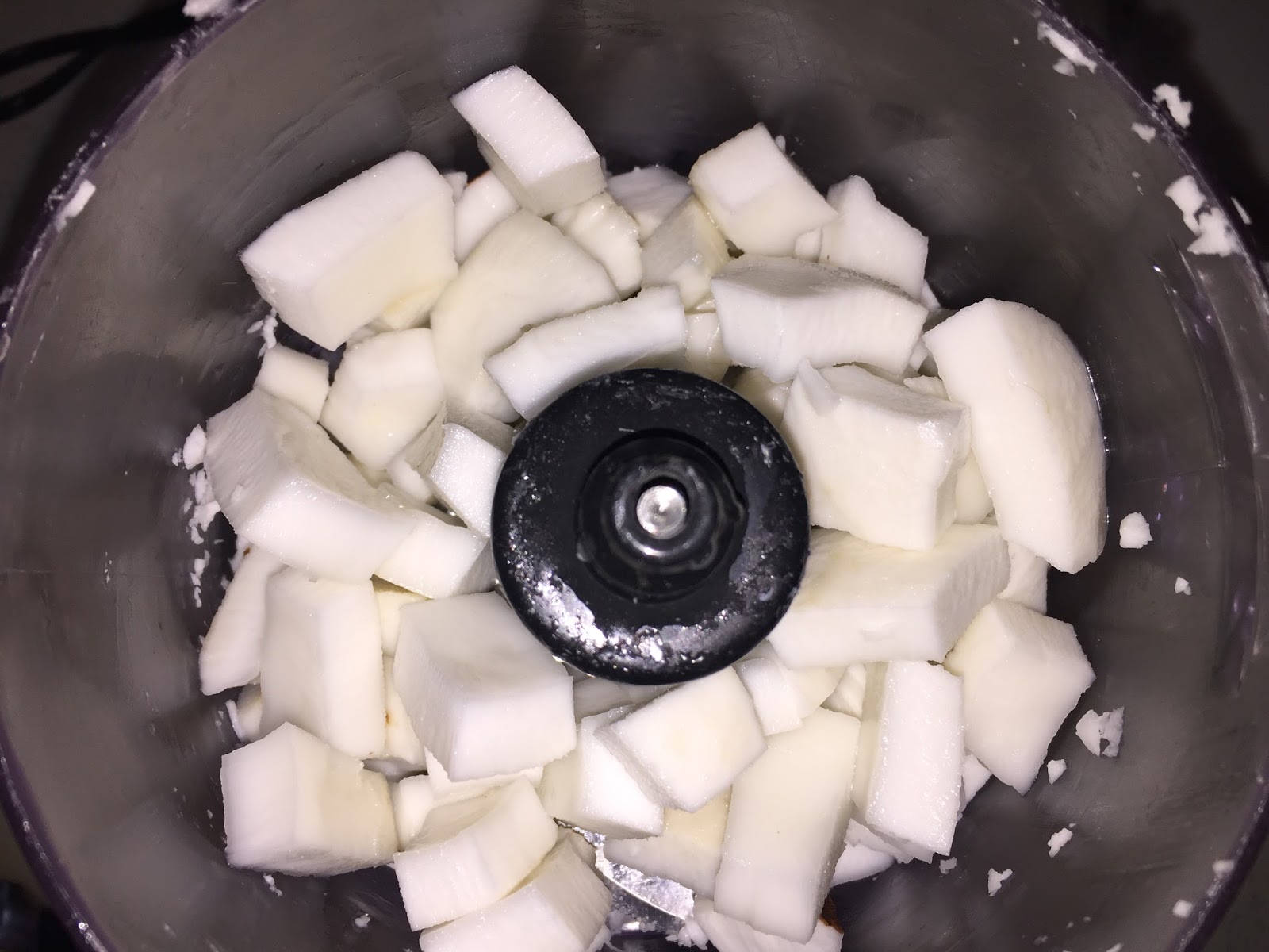 Grating fresh coconut meat in food processor.