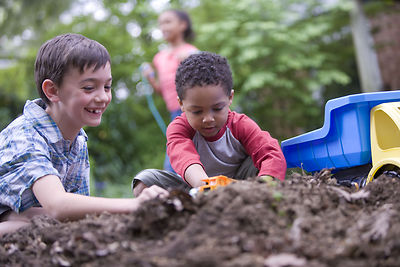 Two boys playing in dirt.
