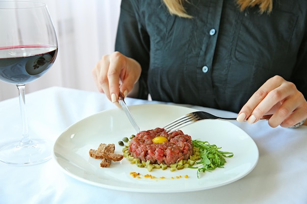 Woman eating beef tartare.